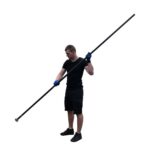 Lifestylefoto van man in zwarte outfit met blauwe werkhandschoenen die een lange aluminium prikstok met vismagneet vasthoudt.