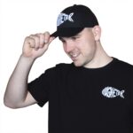 Zwarte Magnetar pet met wit vislogo, gecombineerd met zwart T-shirt met hetzelfde logo, casual en sportieve uitstraling.