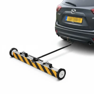 Magnetische terreinbezem met wielen en trekstang achter auto, hero afbeelding, voor het opruimen van metaal op oprit en terrein